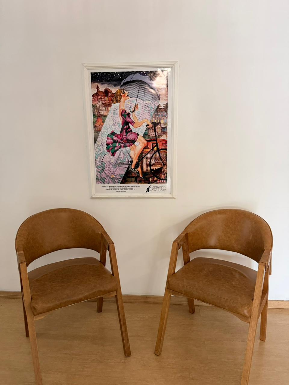 Recepção acolhedora com poltronas e arte de Joinville